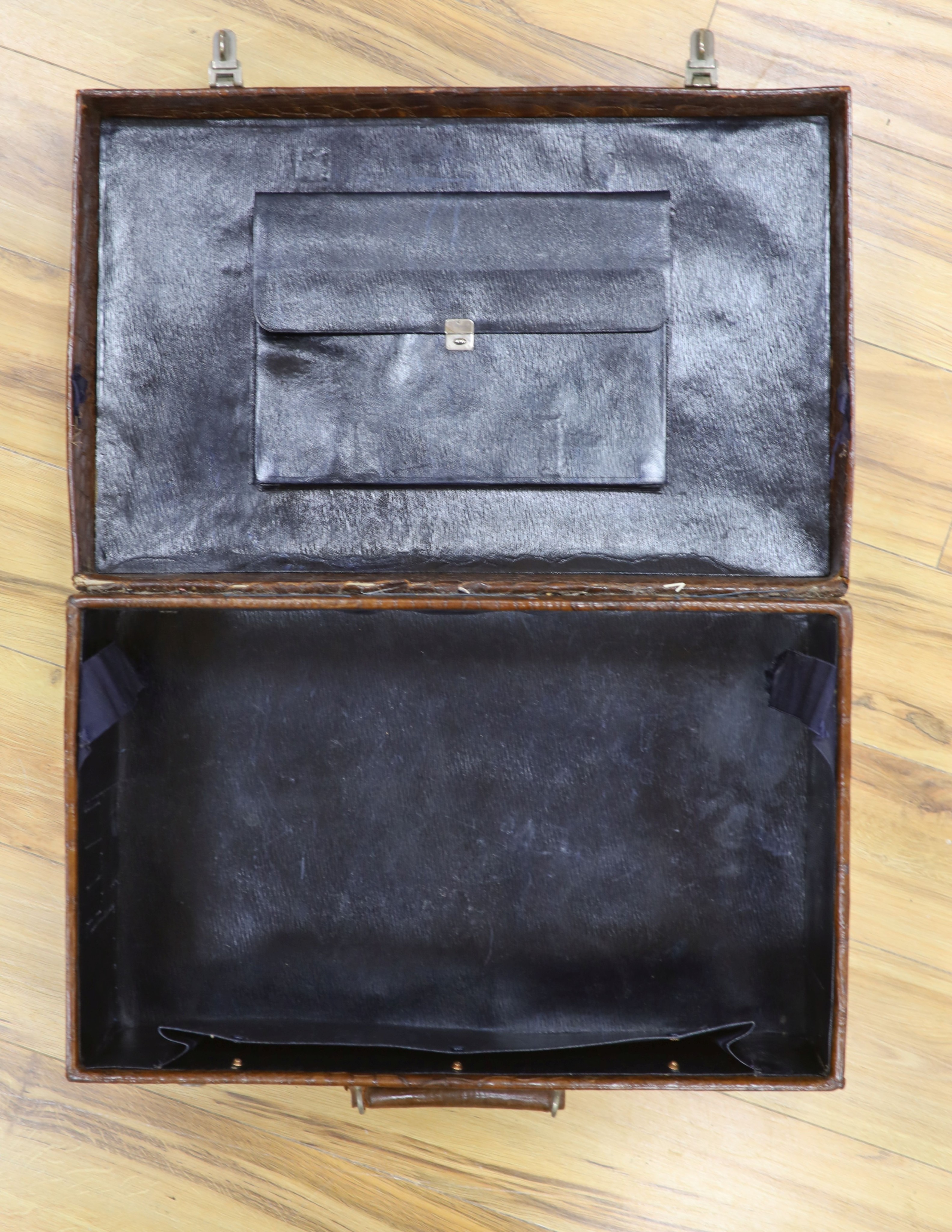 An early 20th century crocodile skin suitcase with blue leather lined interior 61cm